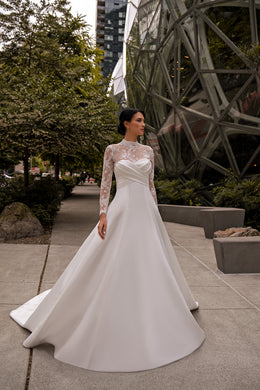 Ivory A-line wedding dress with a sweetheart bodice, sheer lace sleeves, and a sweeping train
