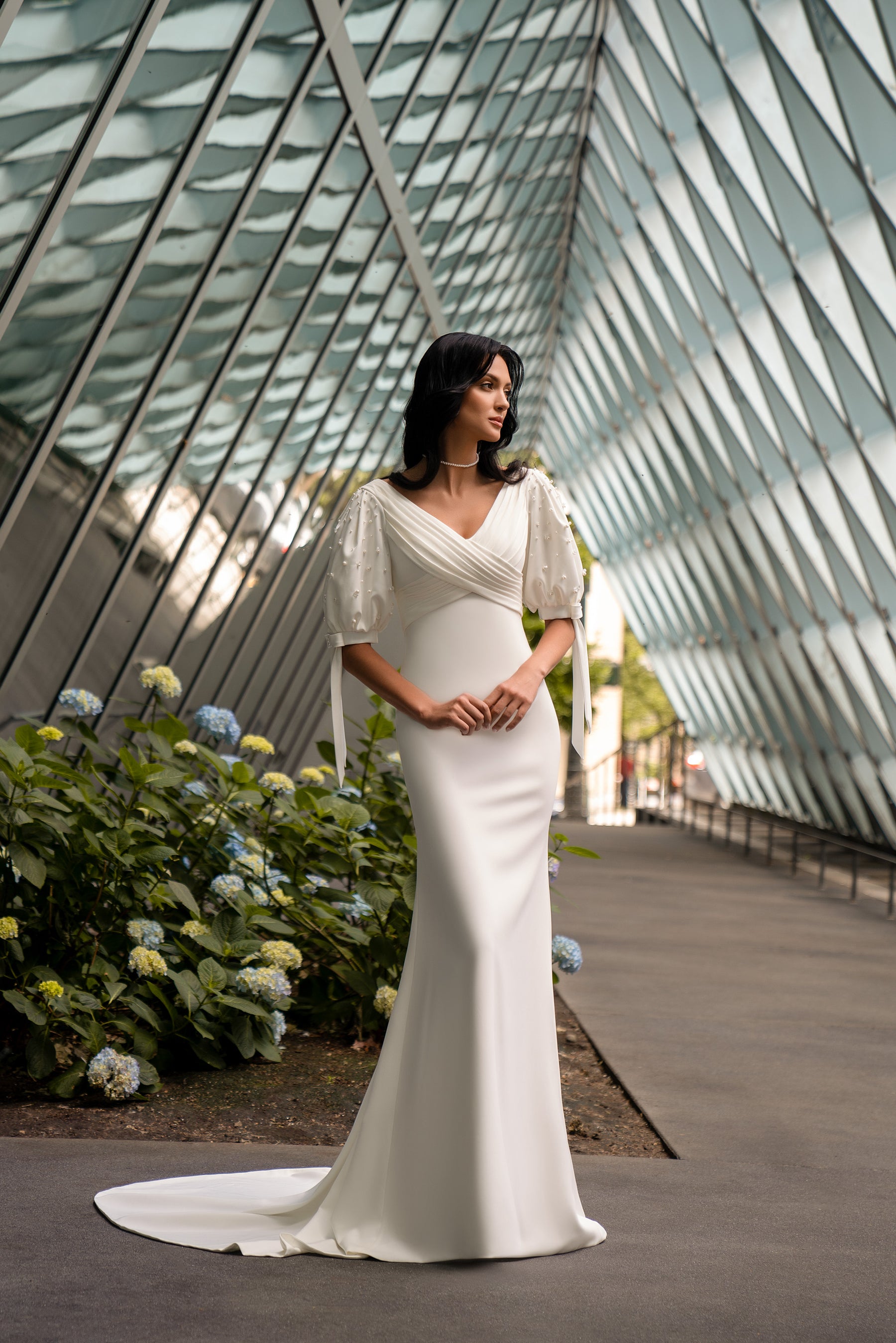 Ivory sheath wedding dress with a V-neckline, short puff sleeves, and a sweeping train