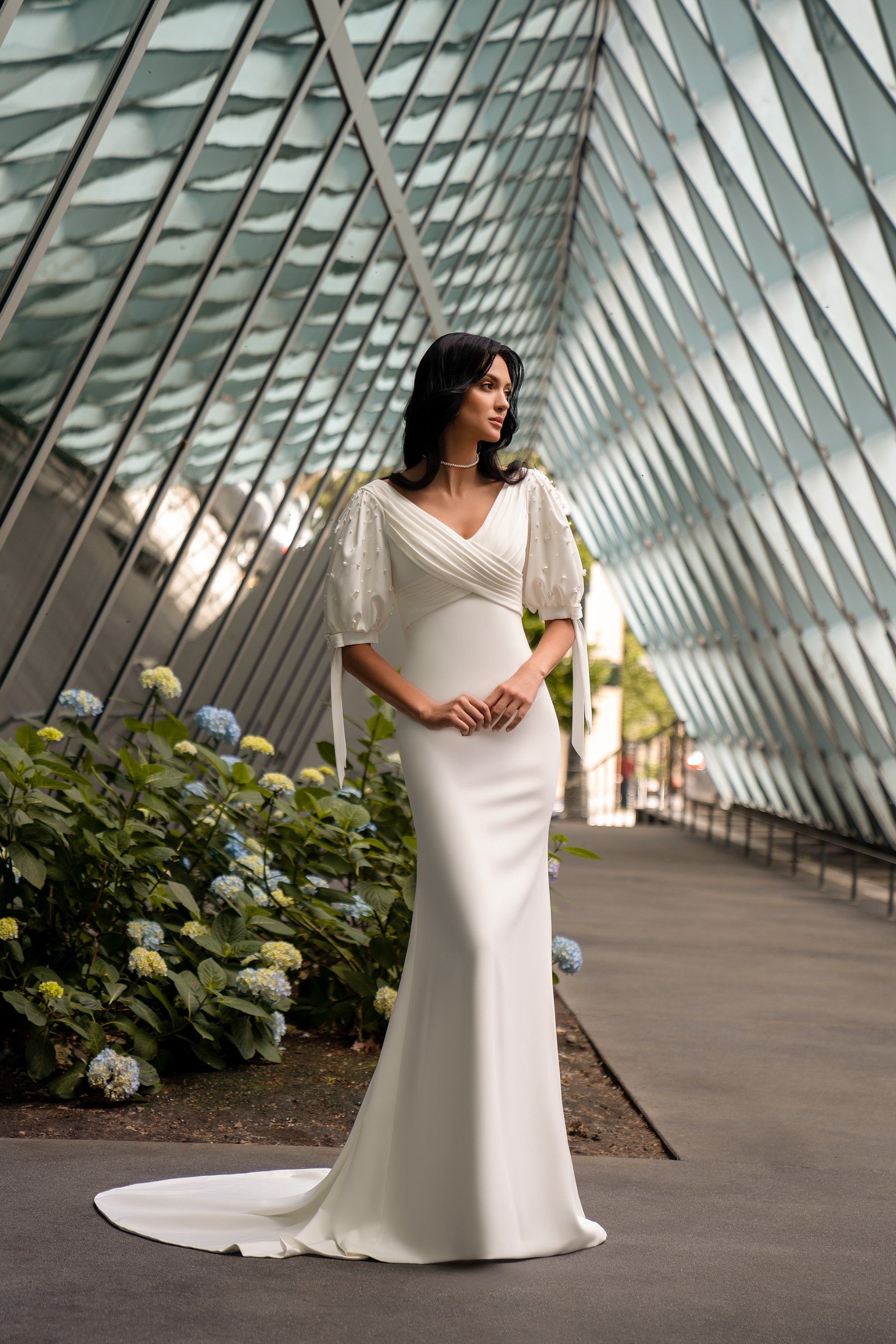 Ivory sheath wedding dress with a V-neckline, short puff sleeves, and a sweeping train