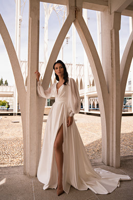 Ivory A-line wedding dress with a draped V-neck bodice, long sleeves, high slit, and sweeping train