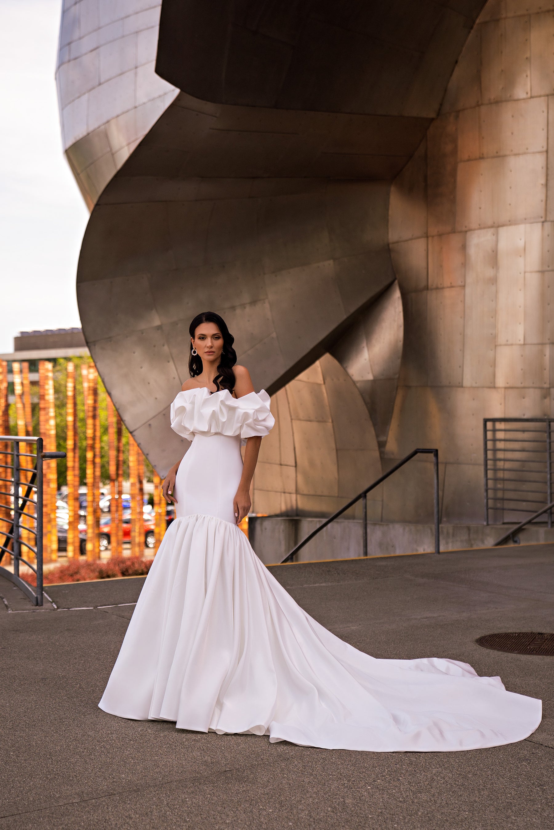 White mermaid wedding dress with an off-the-shoulder ruffled bodice and sweeping floor-length train