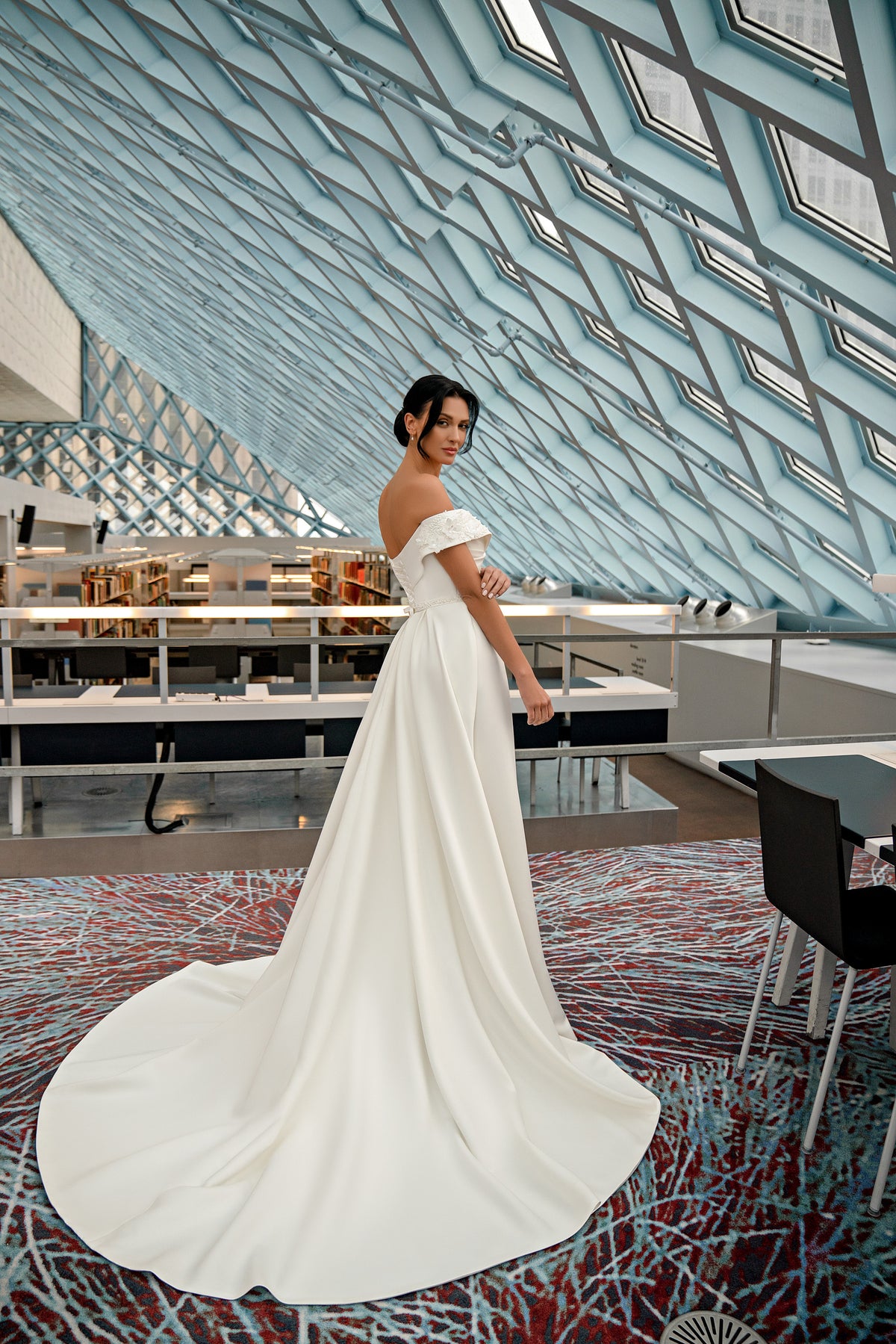 Ivory off-the-shoulder wedding dress with a flowing full-length train and softly draped A-line skirt