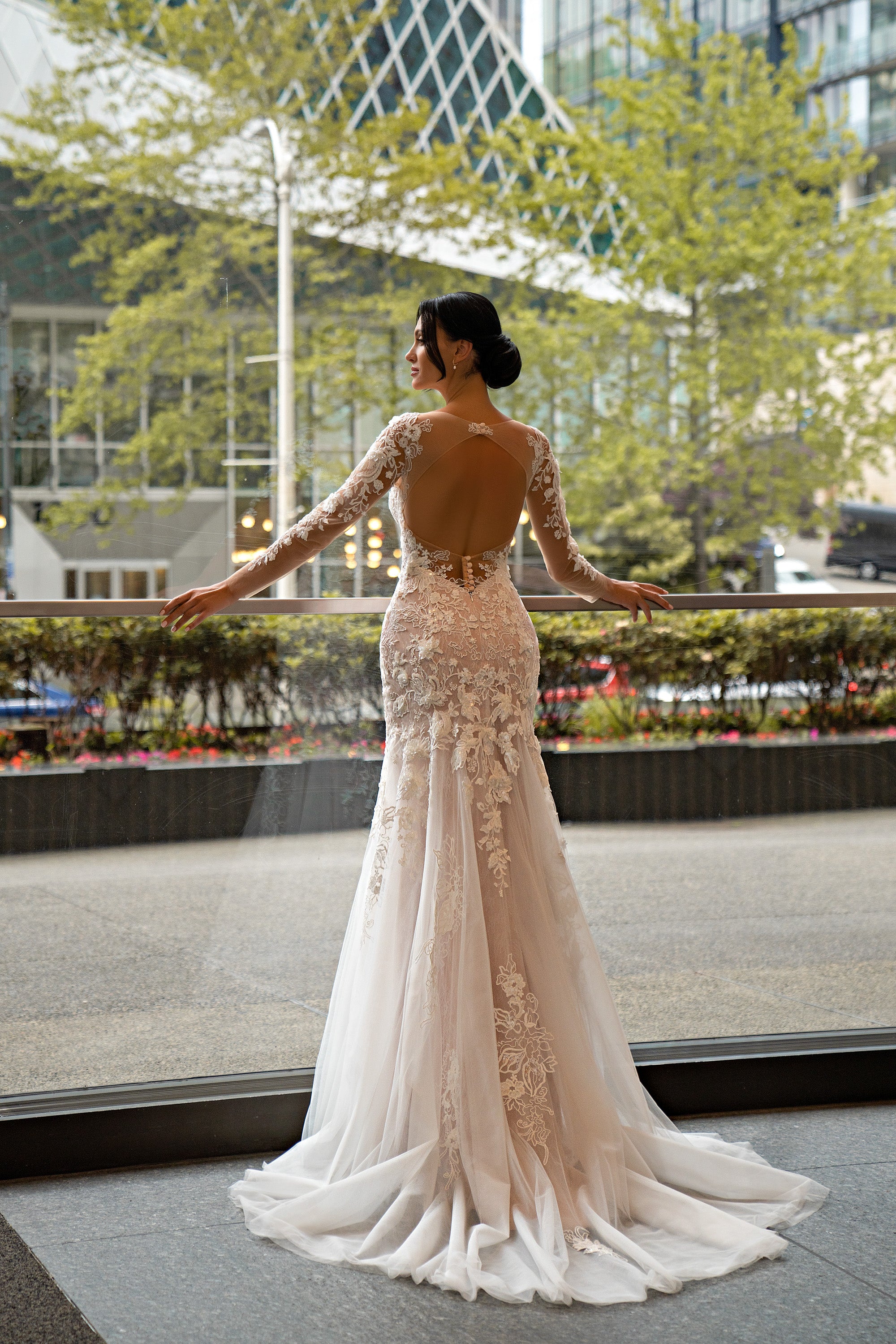 Open illusion back with floral lace sleeves and train on an ivory mermaid wedding dress