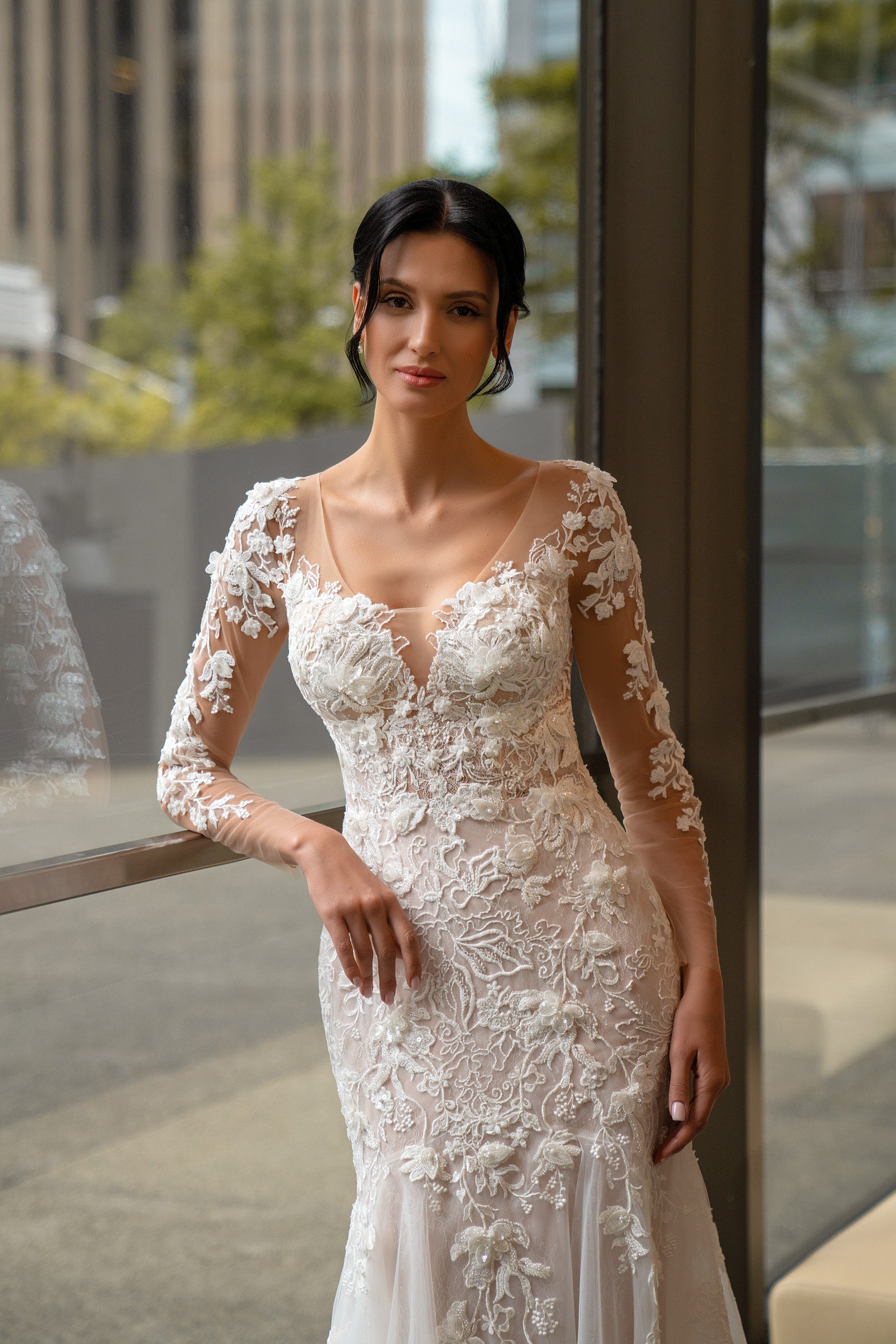 Close-up of floral lace appliqué and beadwork on the V-neck bodice of an ivory wedding dress