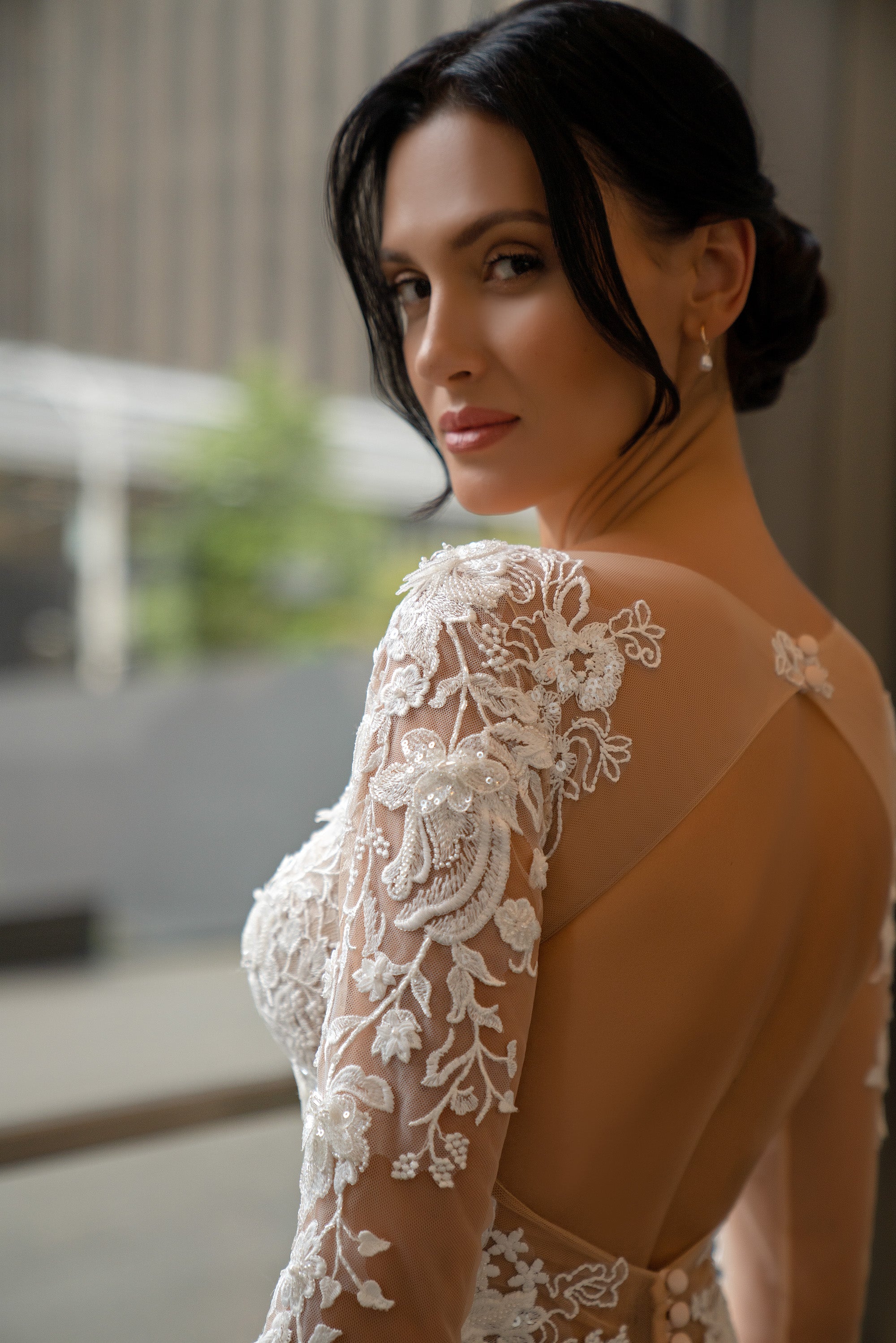 Sheer illusion open back with floral lace long sleeve on an ivory mermaid wedding dress