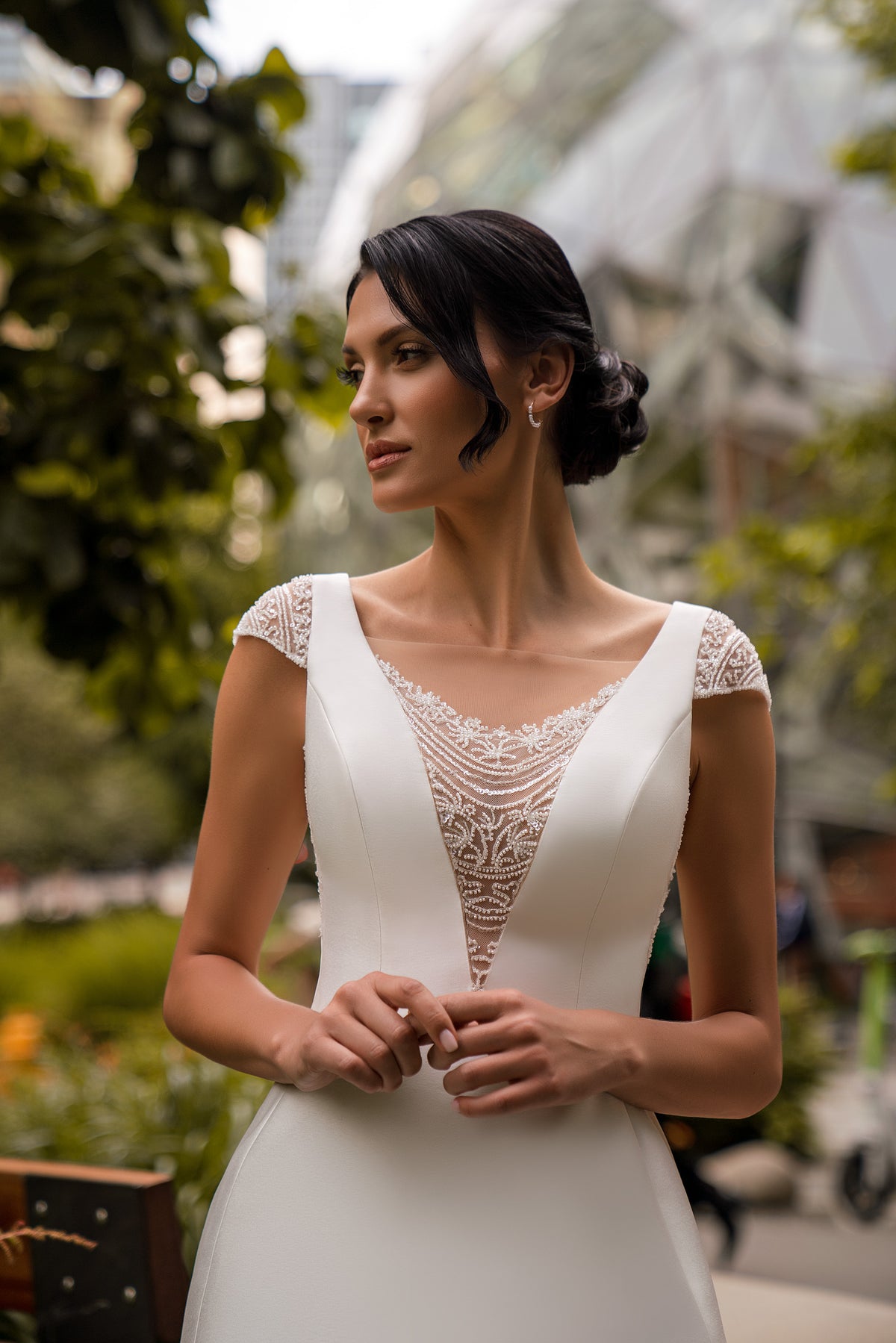 Close-up of beaded lace illusion V-neckline and cap sleeves on an ivory wedding dress