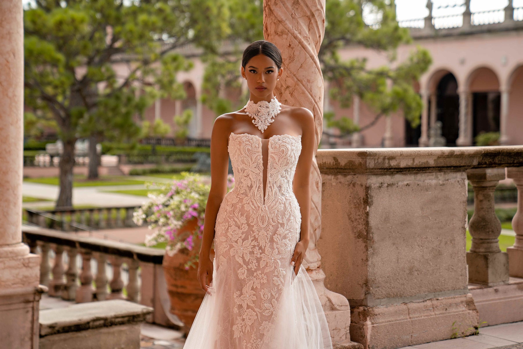 Close-up of an ivory wedding dress bodice with floral lace, strapless sweetheart neckline, and lace high-neck collar