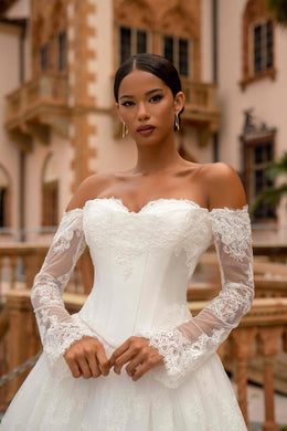 Ivory wedding dress with an off-the-shoulder neckline, fitted bodice, and sheer floral lace sleeves