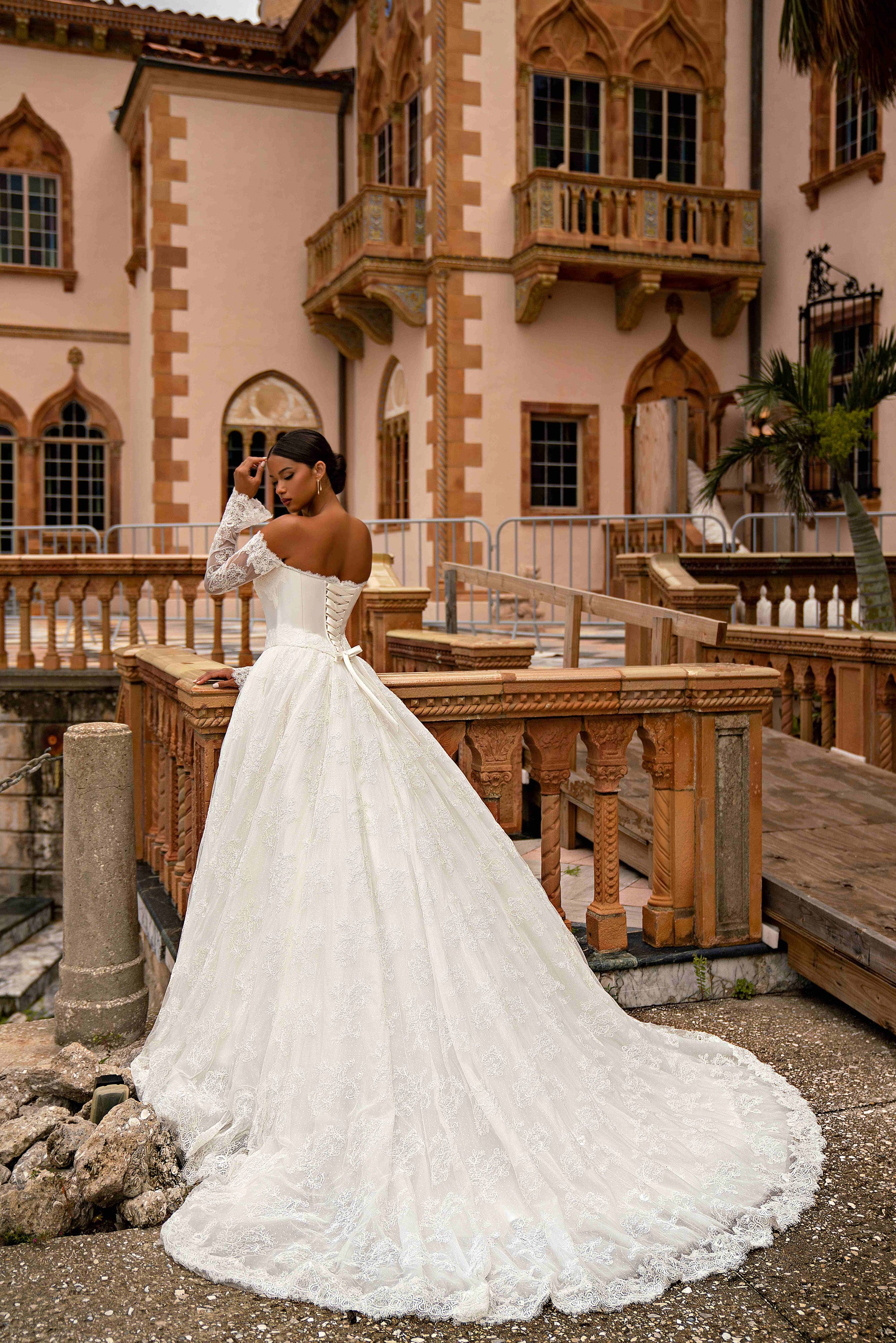 Ivory lace wedding dress with long sleeves, an A-line skirt, and a sweeping train