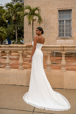 Back view of a white strapless wedding dress with an open back and fitted train
