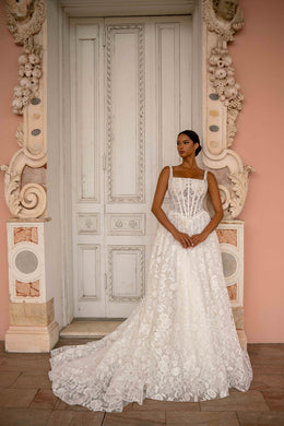 Ivory A-line wedding dress with a square neckline, corset-style bodice, floral lace, and a sweeping train