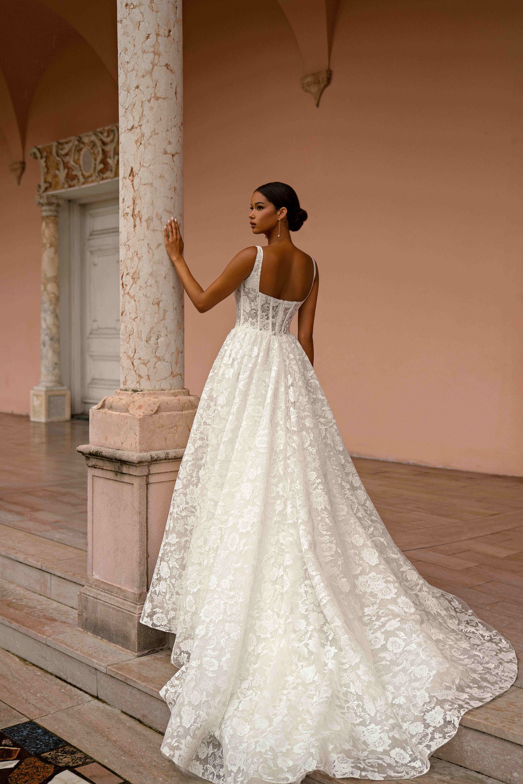 Lace-back ivory wedding dress with slender straps, an open low back, A-line skirt, and a long train