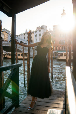 Black evening dress with a sweetheart neckline, silver beaded cap sleeves, and a floor-length skirt