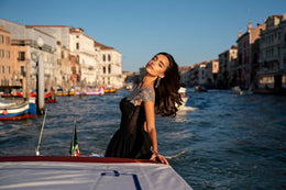 Black evening dress shown in profile with glittering silver cap sleeves and a long flowing skirt