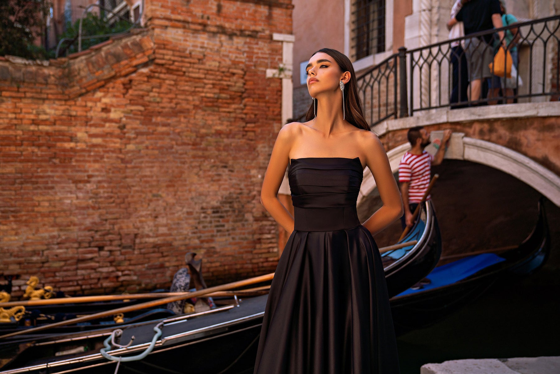 Black strapless evening dress with a ruched bodice and long, softly pleated full skirt