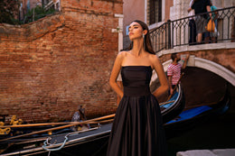 Black strapless evening dress with a ruched bodice and long, softly pleated full skirt