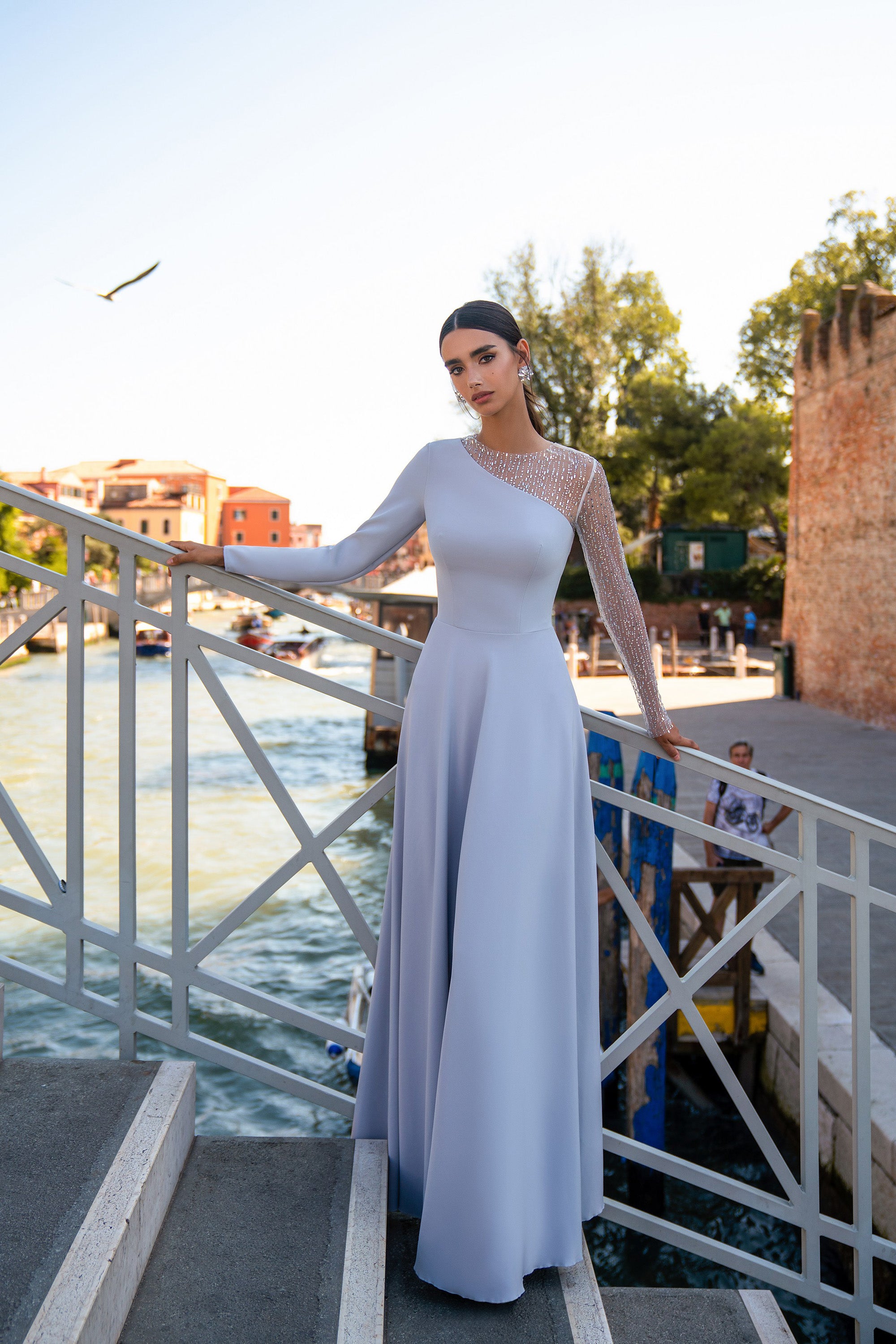 Pale lavender evening dress with a floor-length A-line skirt, long sleeves, and a sparkling sheer shoulder panel