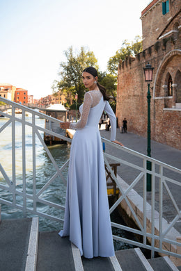 Pale lavender evening dress with a flowing floor-length skirt and a sheer, embellished upper back and sleeve