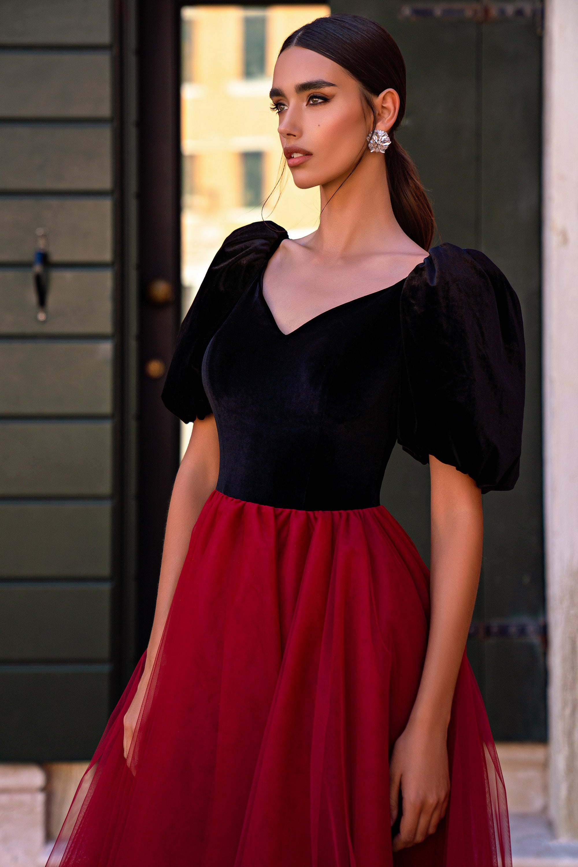 Black velvet-look evening dress with puff sleeves, V-neck bodice, and a full red tulle skirt