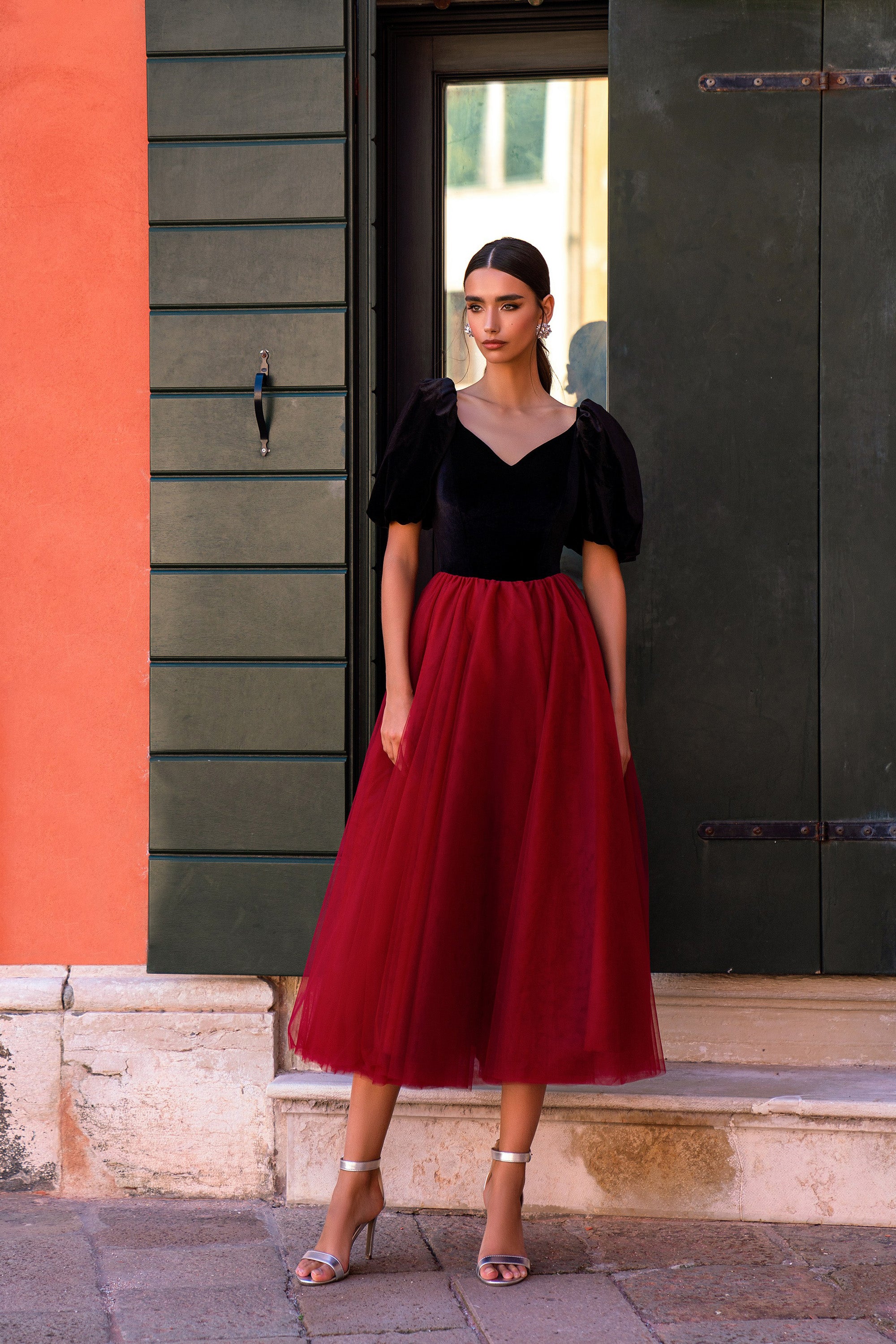 Black-and-red evening dress with a V-neck bodice, puff sleeves, and a flowing midi-length skirt