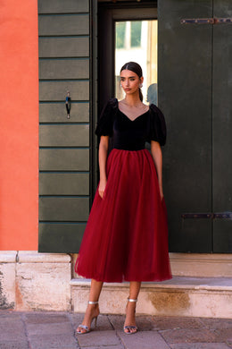 Black-and-red evening dress with a V-neck bodice, puff sleeves, and a flowing midi-length skirt