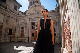 Black evening dress with a sleeveless plunging V-neck, embellished bodice, and full flowing skirt