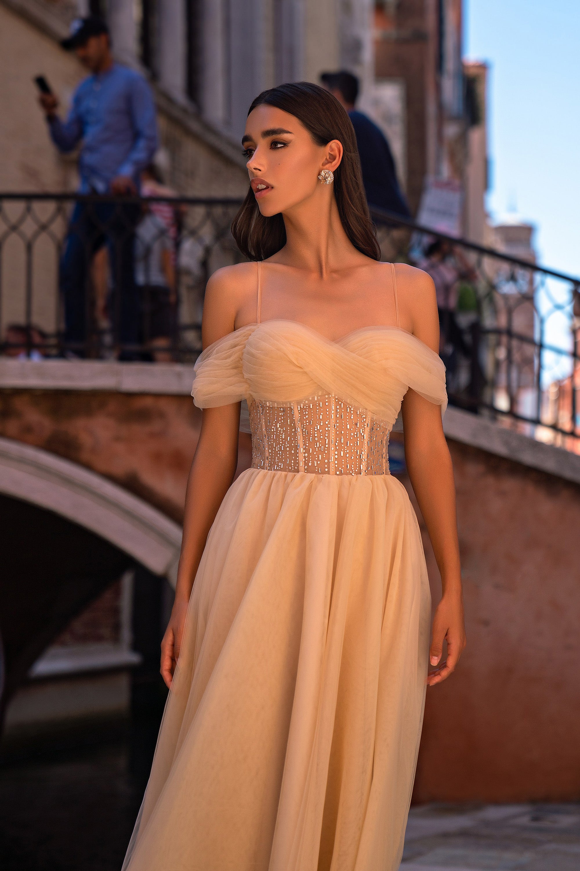Champagne evening dress with a glittering corset bodice, sheer off-shoulder sleeves, and a flowing skirt