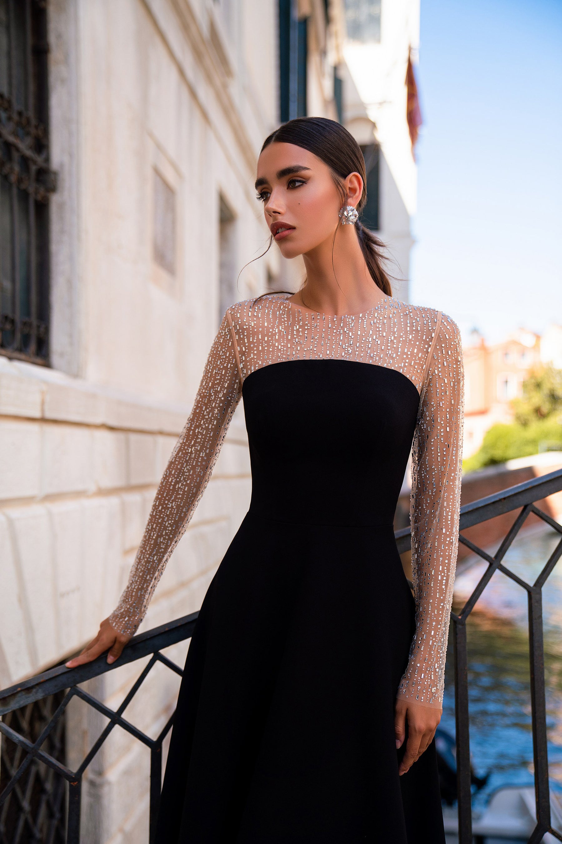 Fitted black evening dress with a straight strapless neckline and sparkling sheer long sleeves
