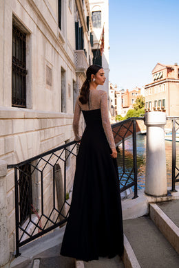 Black evening dress with a full-length skirt and a sheer, rhinestone-embellished back and sleeves