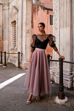 Black bodice and sheer puff sleeves with a flowing mauve skirt on an evening dress