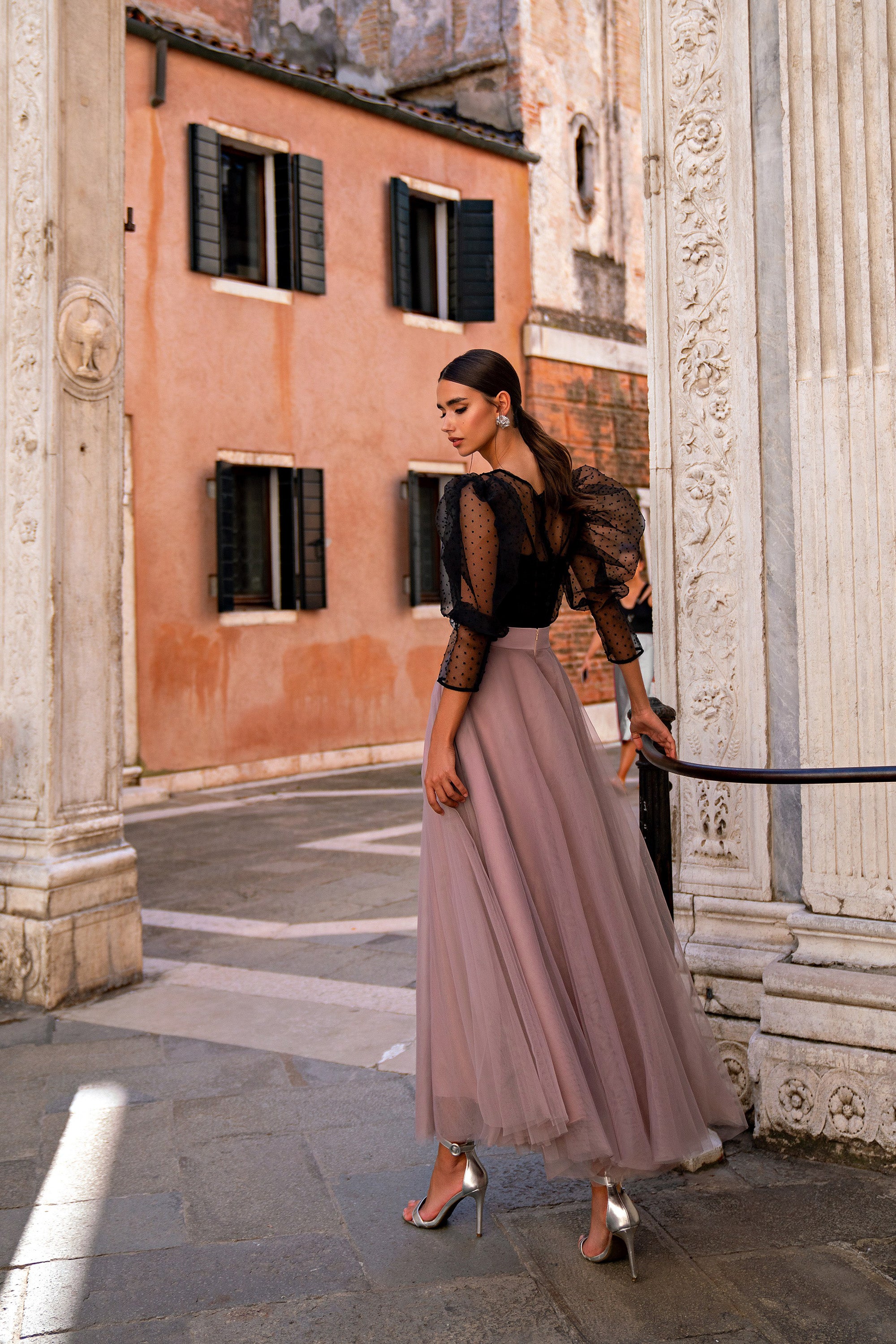 Side view of a mauve evening dress with a black bodice, sheer puff sleeves, and a full skirt