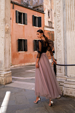 Side view of a mauve evening dress with a black bodice, sheer puff sleeves, and a full skirt