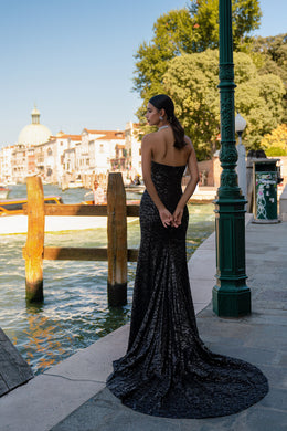 Open-back black sequined evening dress with a strapless design and dramatic circular train