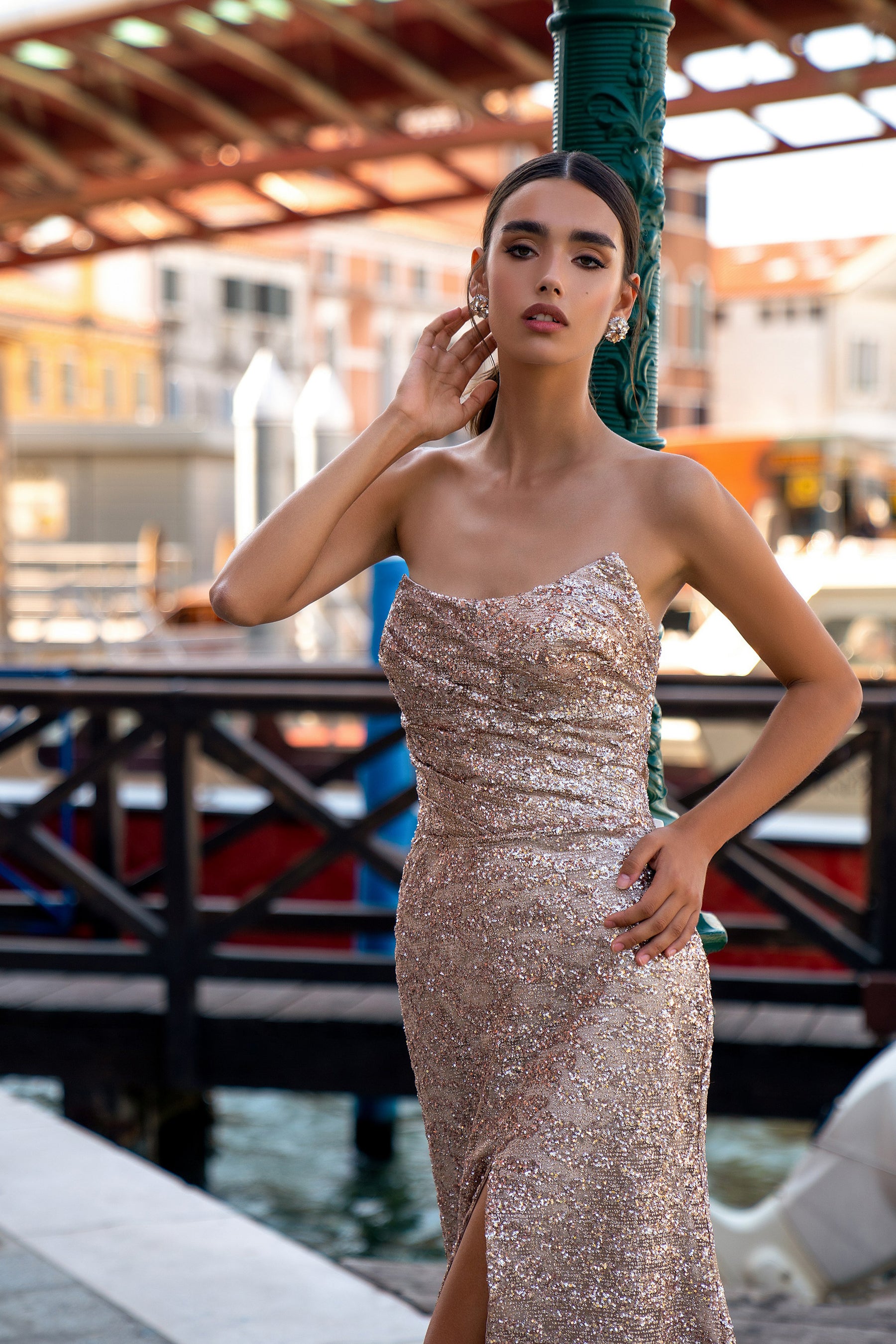 Close-up of a rose gold sequined evening dress with a strapless neckline and front slit