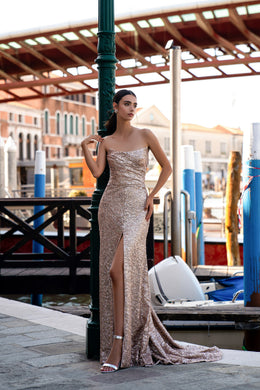 Rose gold sequined evening dress with a strapless neckline, thigh-high slit, and trailing train