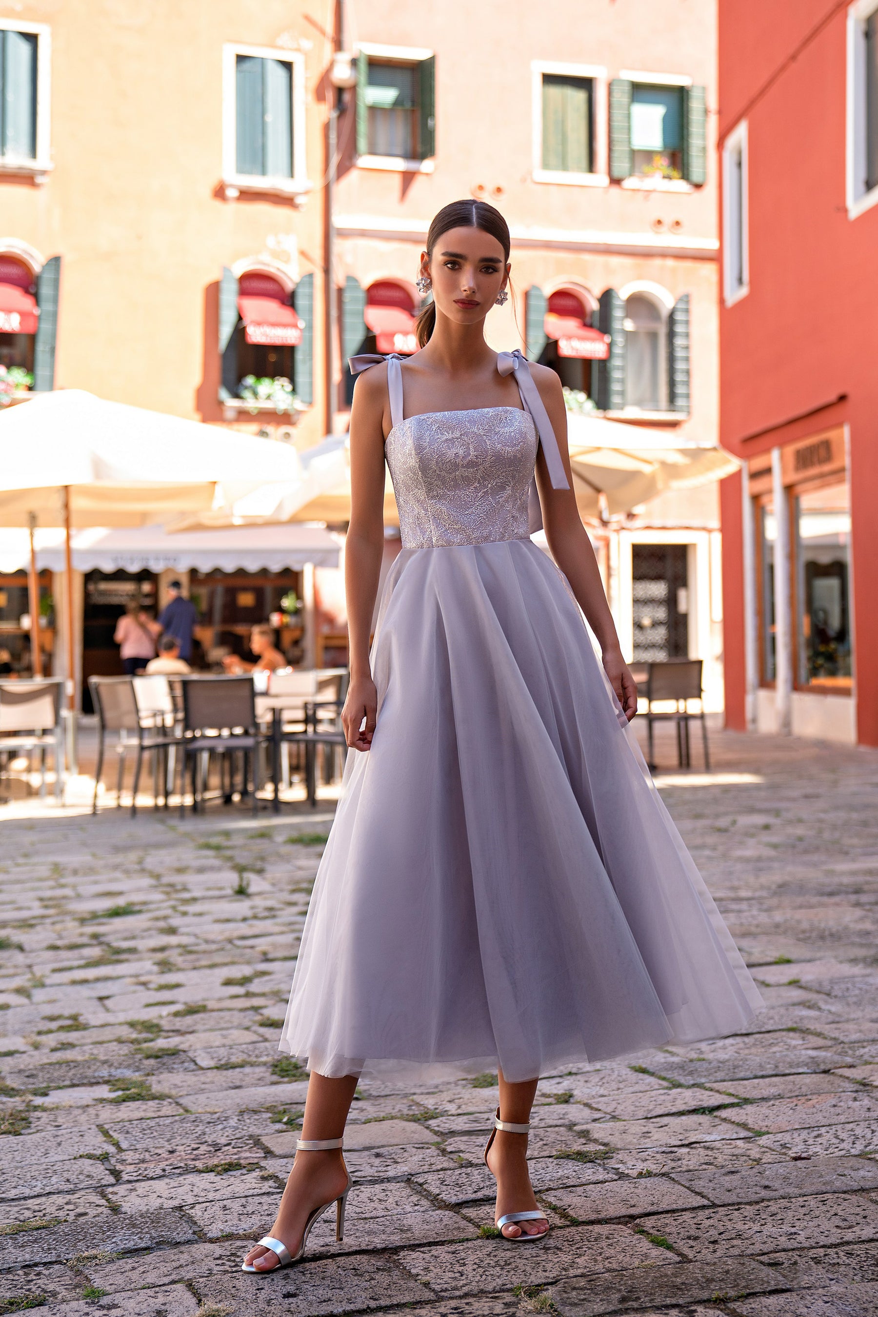 Ivory evening dress with a fitted sequin bodice, square neckline, ribbon straps, and flowing midi skirt