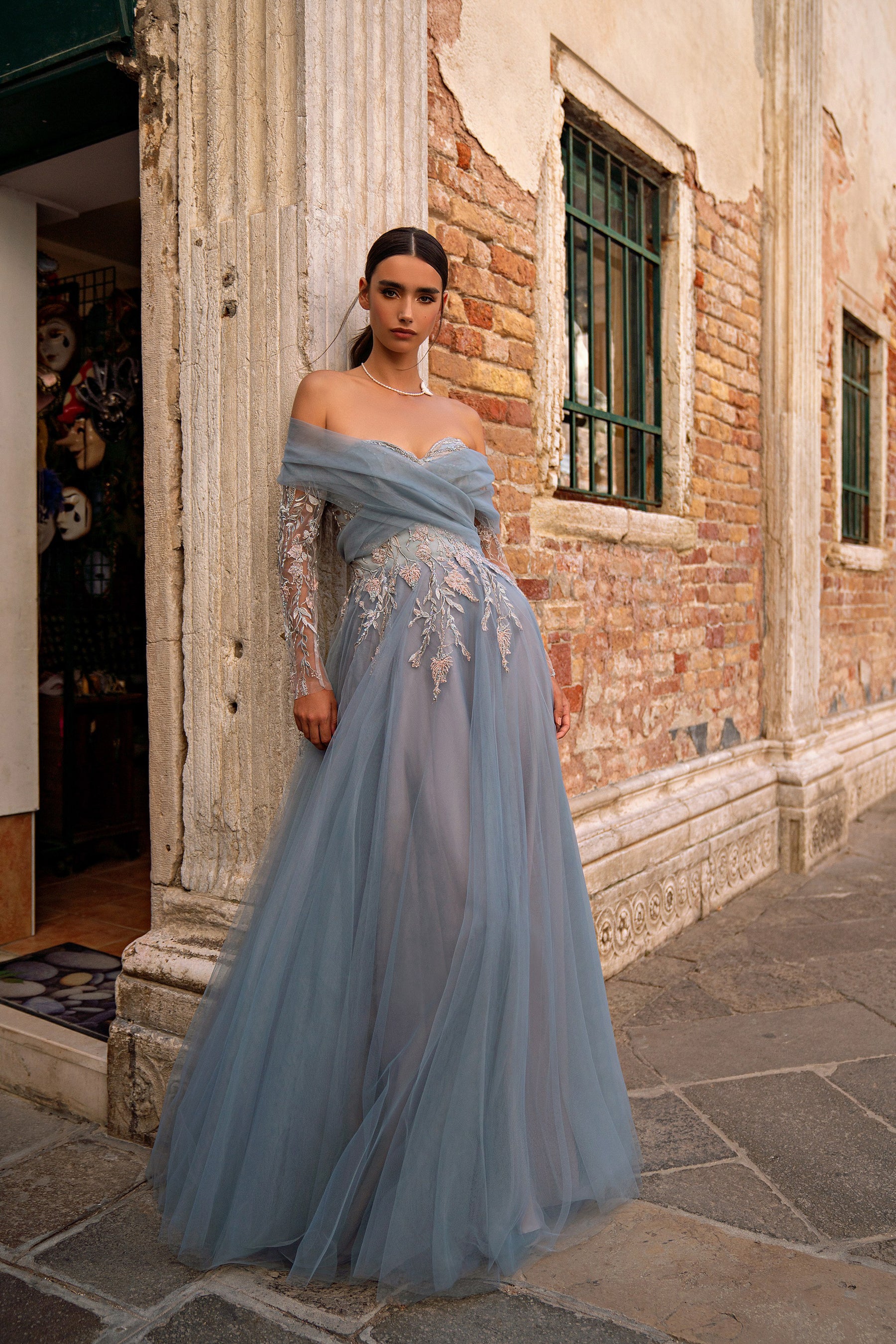 Blue-gray evening dress with a sheer off-the-shoulder overlay and floral embroidery cascading down the skirt