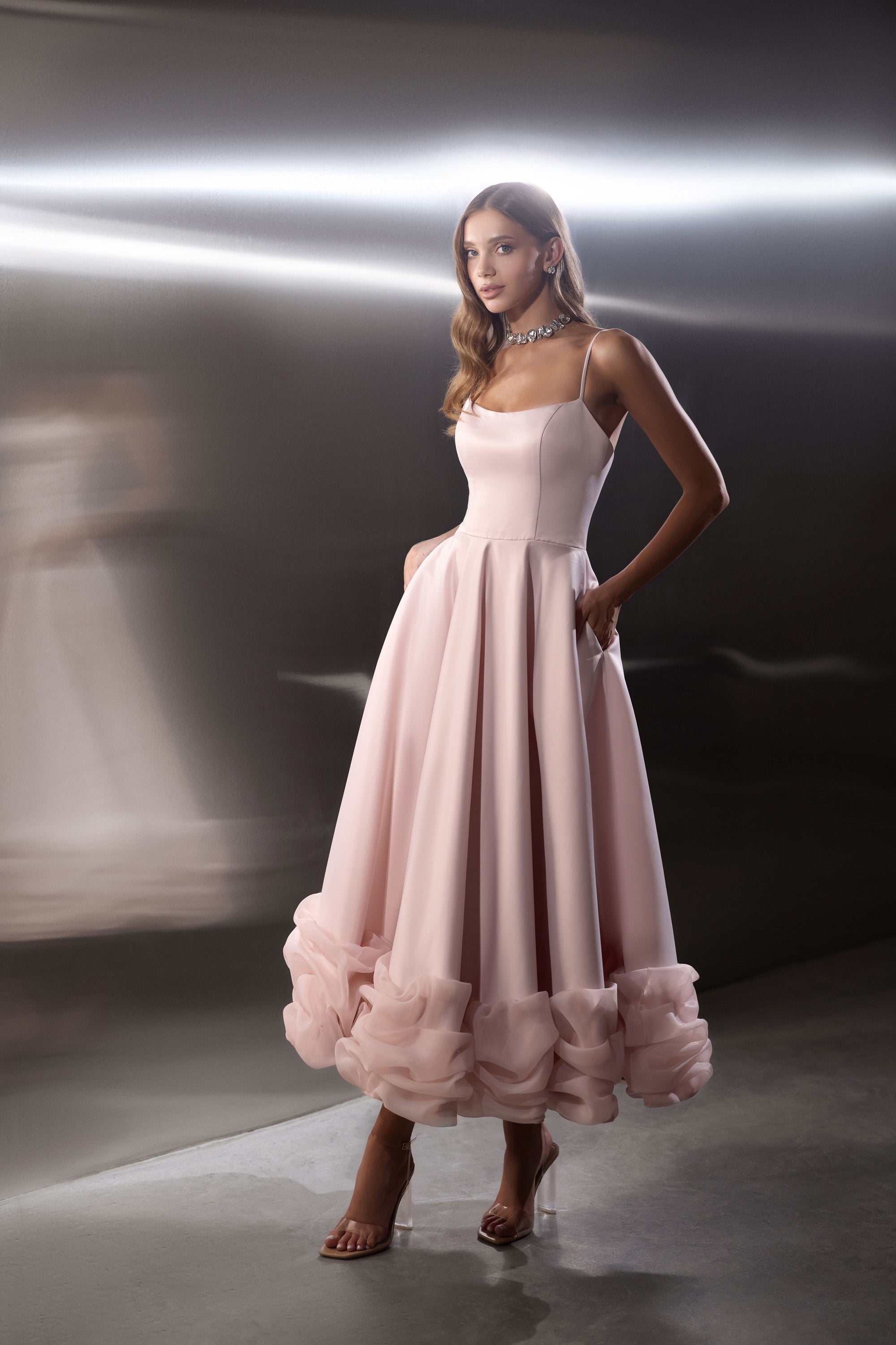 Blush pink evening dress with a square neckline, fitted bodice, full skirt, and ruffled hem