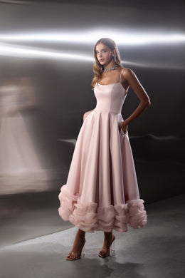 Blush pink evening dress with a square neckline, fitted bodice, full skirt, and ruffled hem