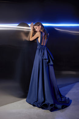 Navy evening dress with a low open back, gathered waist detail, full skirt, and sweeping train