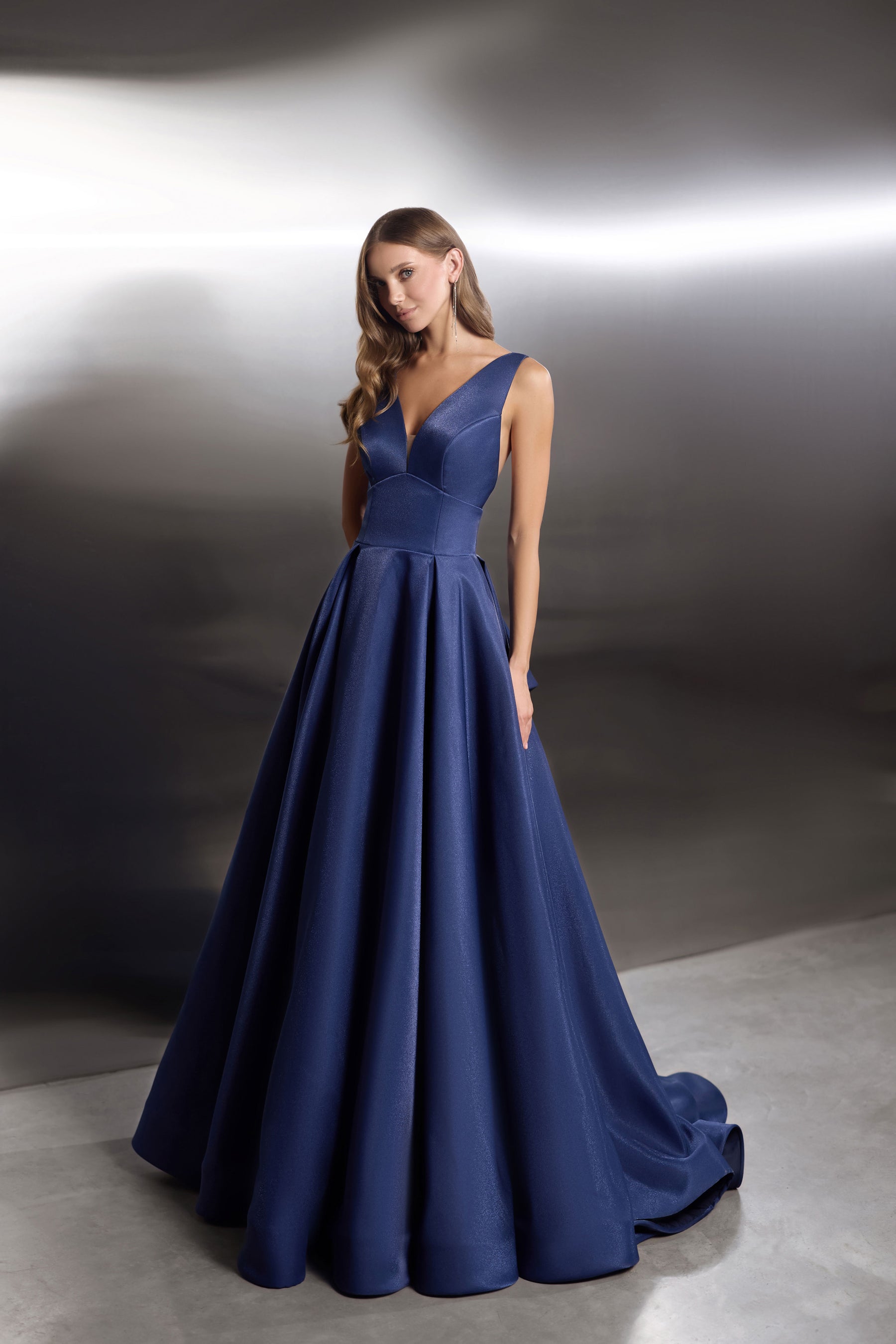 Navy evening dress with a V-neck bodice, sleeveless design, and wide flowing ballgown skirt