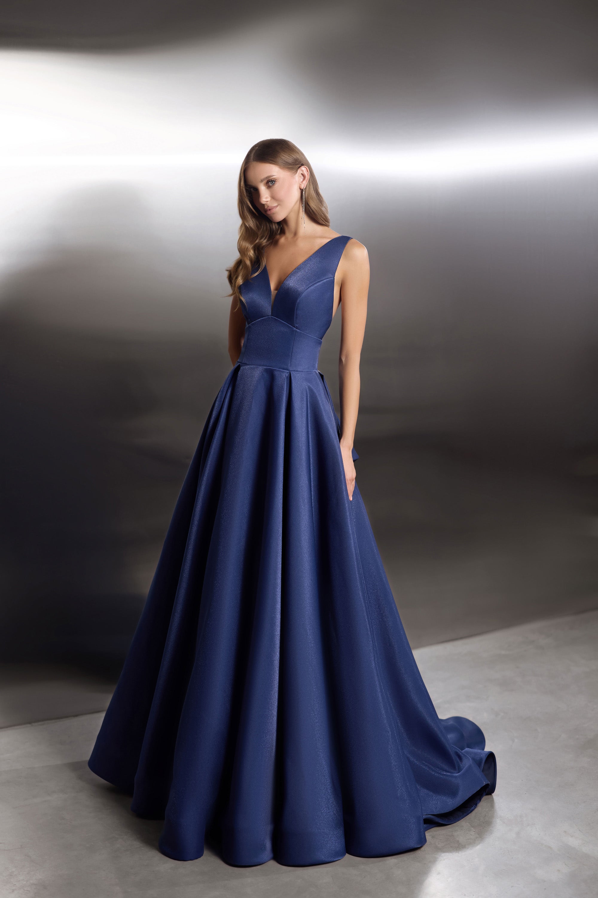 Navy evening dress with a V-neck bodice, sleeveless design, and wide flowing ballgown skirt