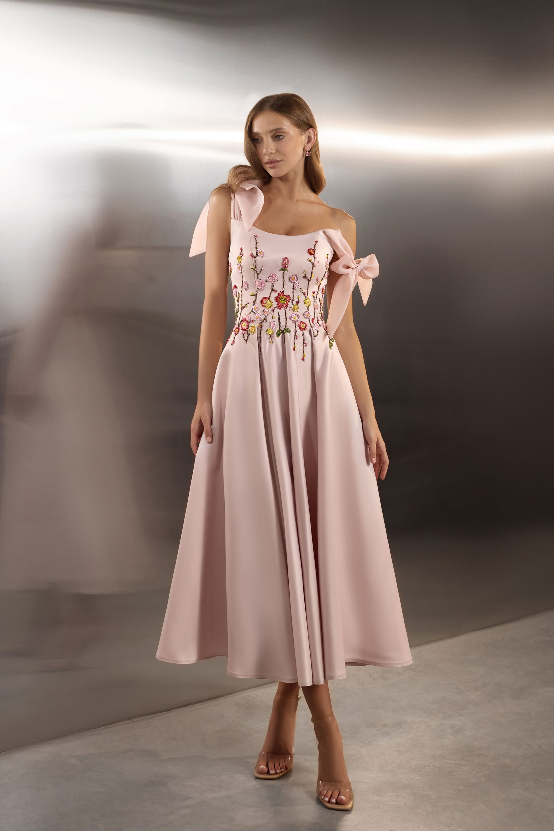 Blush pink evening dress with floral embroidery, square neckline, ribbon shoulder bows, and a flowing A-line skirt