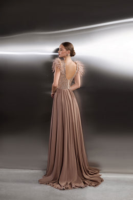 Open deep-V back on a taupe evening dress with feathered sleeves and a flowing pleated train