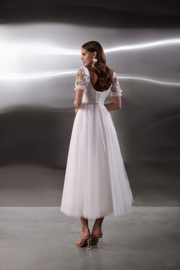 Open rounded back with waist lacing and floral sleeves on a white tulle evening dress