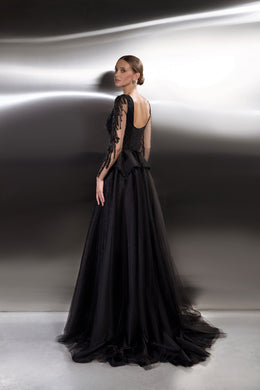 Low open back and sheer embellished sleeves on a black evening dress with a sweeping floor-length train