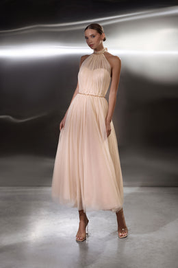 Blush pink evening dress with a halter neckline, beaded bodice, defined waist, and flowing midi skirt