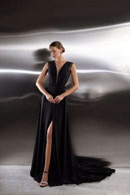 Black evening dress with a deep V-neckline, sleeveless bodice, thigh-high slit, and sweeping train