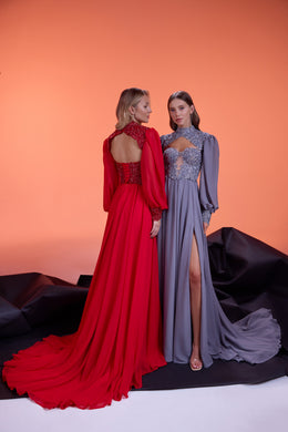 Lavender-gray evening dress with a jeweled bodice, long sleeves, thigh-high slit, and flowing train