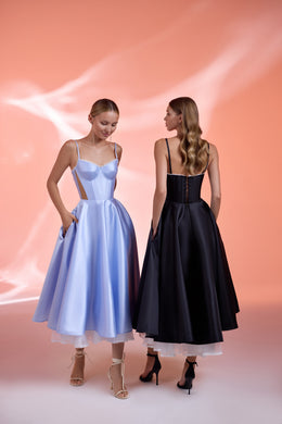 Black evening dress with a structured corset back and full skirt, shown beside a lavender strappy dress